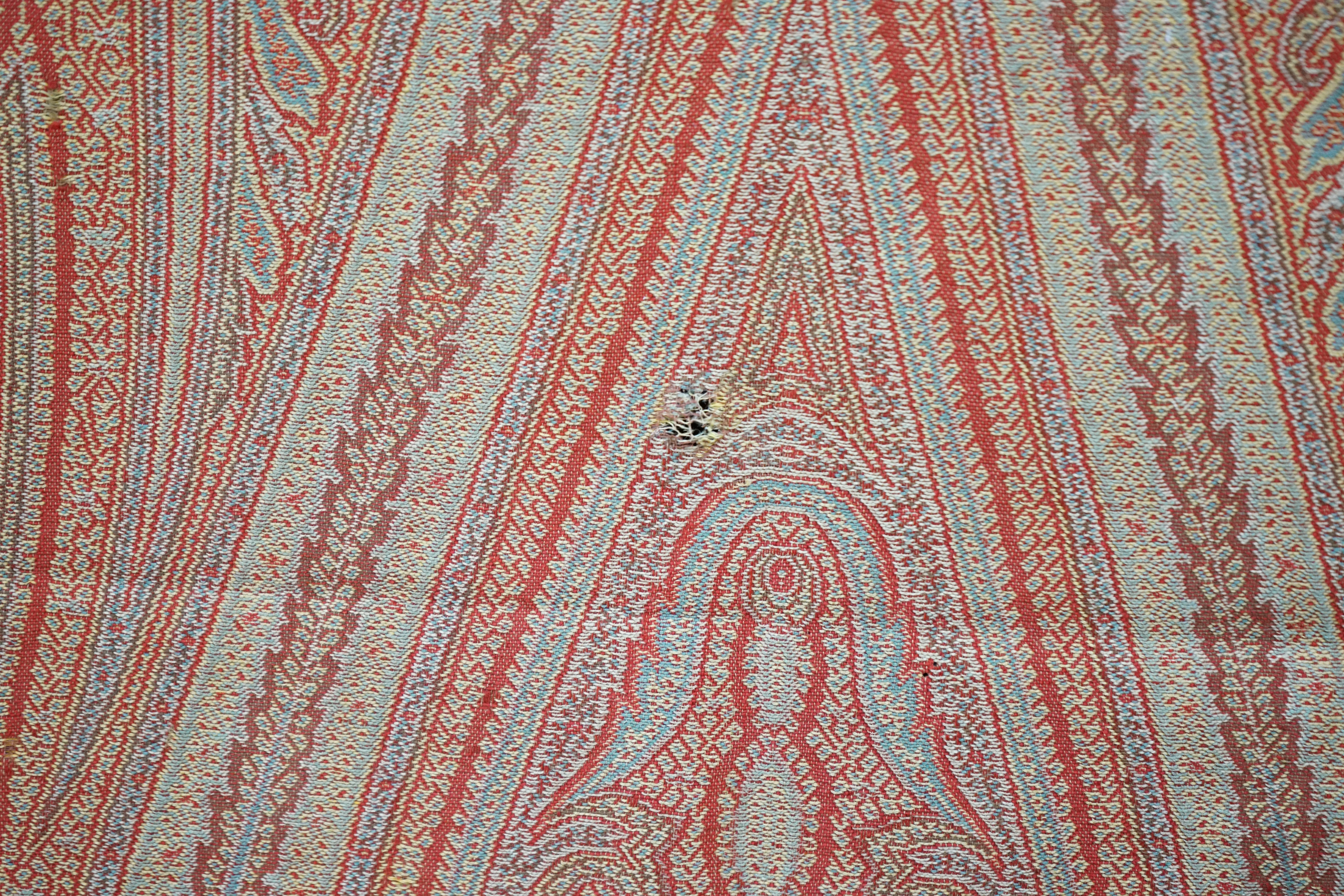 A Victorian wool woven Paisley shawl, designed with a large central tear drop, with intricate paisley design, woven in reds, blues, greens and yellows, the pattern from centre to left and centre to right the same, 160cm